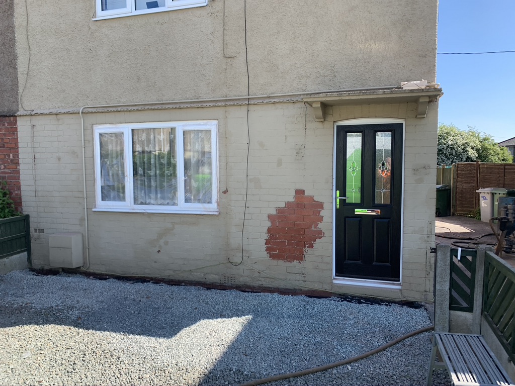 Painted front of house with paint removal started