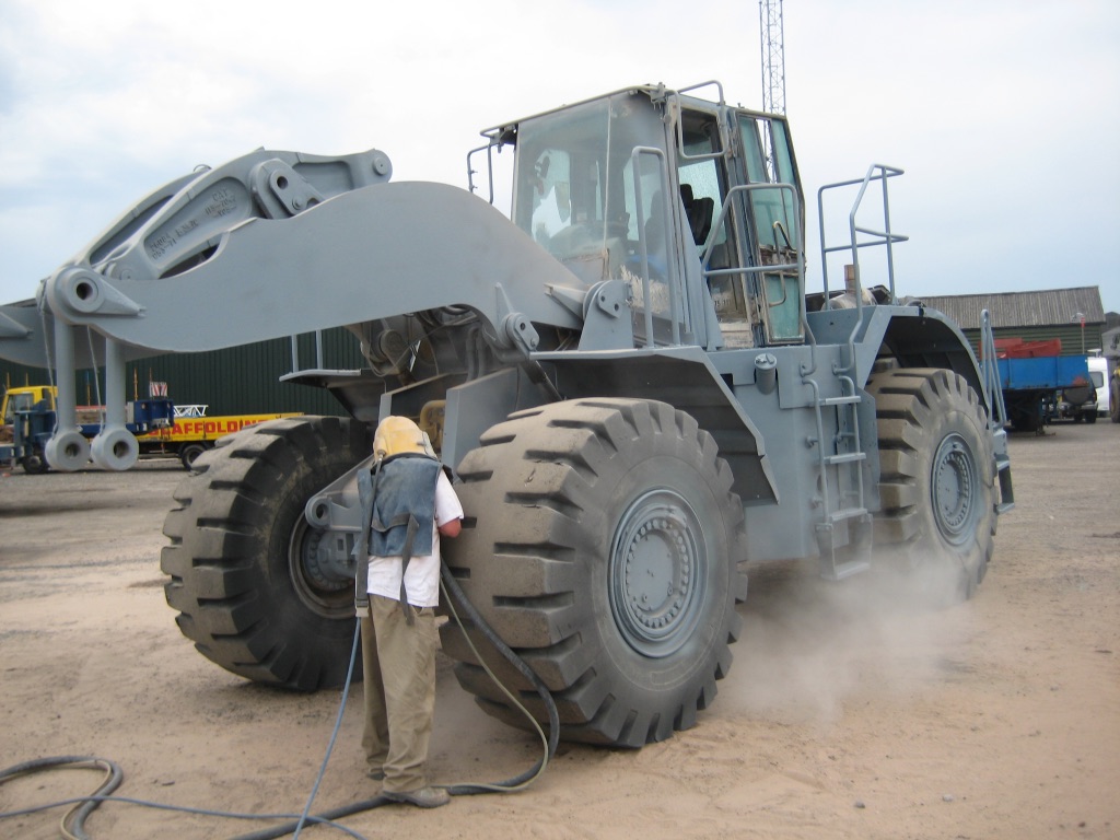 Blast cleaning CAT earthmover